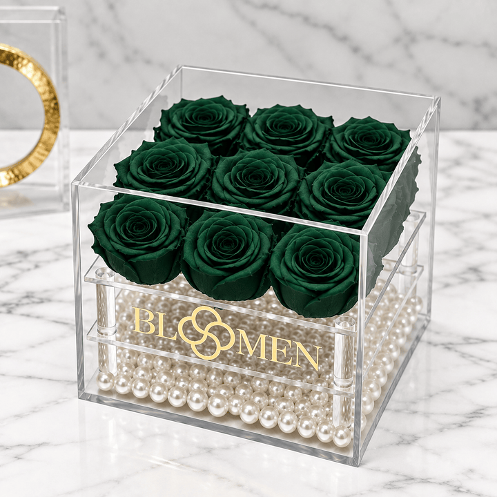 Nine hunter green everlasting roses in a clear Bloomen box with decorative beads, angled view