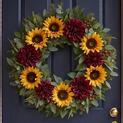 Fall door wreath with golden sunflowers and burgundy dahlias, close-up on a navy front door
